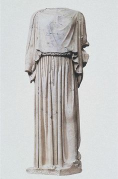 an ancient statue is shown against a white background in this image, it appears to be wearing a long dress