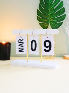 a pair of earrings sitting on top of a table next to a candle and potted plant