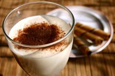 a glass filled with liquid and cinnamon sticks