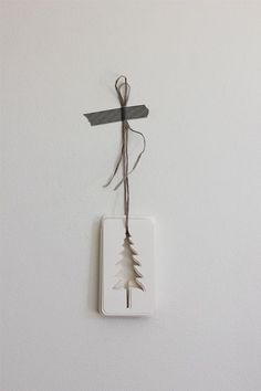 a white wall with a cross hanging from it's side and a string attached to it