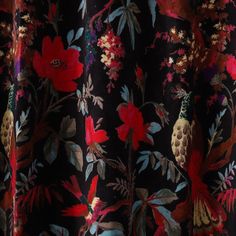 a close up view of a black and red floral print curtain with gold trimmings