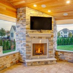 an outdoor fireplace with a television mounted on it's side in the middle of a patio