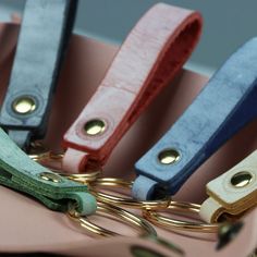 four pairs of scissors sitting on top of a pink bag with gold handles and metal hooks