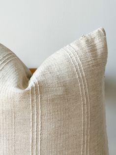 a close up of a white pillow on a wooden headboard with a black and white striped design