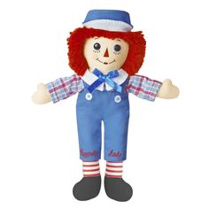 a raggedy doll with red hair and blue overalls is posed for the camera