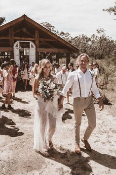 a man and woman walking down a dirt road