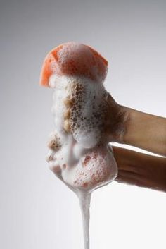 a person holding up a piece of food with icing on it