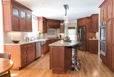 a large kitchen with wooden cabinets and an island in front of the stove top oven