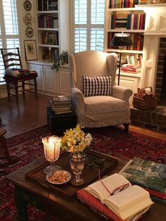 a living room filled with furniture and a fire place in front of a book shelf