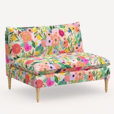 an upholstered floral couch with wooden legs and foot rests on a white background