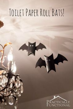 three bats are hanging from a chandelier