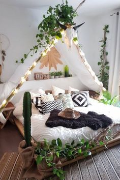 a bed that has some plants on it and lights in the room behind it,