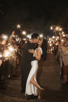 a couple kissing while holding sparklers in their hands