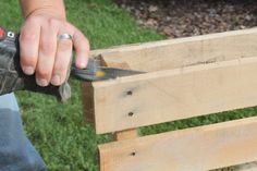 a person using a power tool to cut wood with a bench in front of them