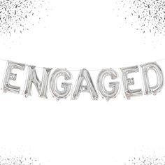 the word engaged spelled out in silver foil on a white background with confetti