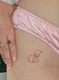 a woman's stomach with a small tattoo of a dog on the side of her belly