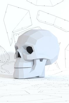 a paper model of a human skull on a white surface with lines and shapes in the background