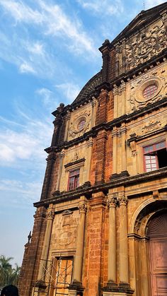 an old building with ornate carvings on the front and side walls, against a blue sky