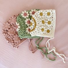 three crocheted purses sitting on top of a pink bed next to each other