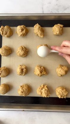 a person is placing an egg in the middle of cookies on a baking sheet