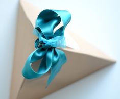 an origami box with a blue ribbon tied around it