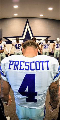 a football player with his back turned to the camera, in front of other players