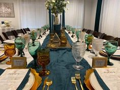 the table is set with gold and green place settings