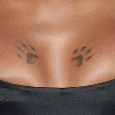 a close up of a woman's chest with paw prints on her chest and breast