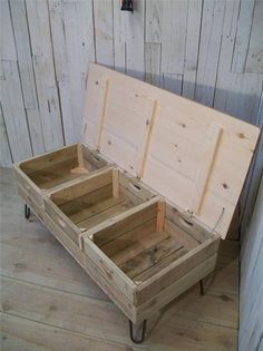 an open wooden box sitting on top of a hard wood floor next to a wall