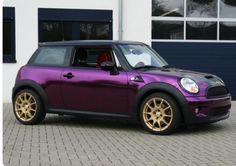 a purple mini with gold rims parked in front of a building