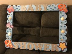 a baby shower frame sitting on top of a couch