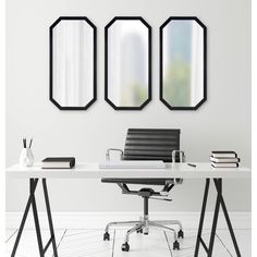 three mirrors are hanging on the wall above a desk with an office chair and books