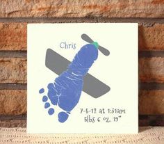 a blue and gray baby's foot print on a white tile with the name christ