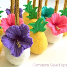 pineapple cake pops decorated with flowers and gold sticks