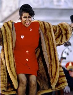 a woman in a red dress and fur coat