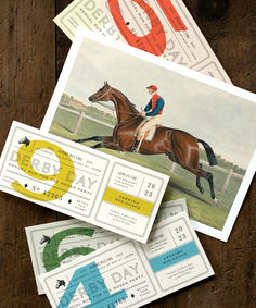 three horse racing tickets sitting on top of a wooden table next to eachother