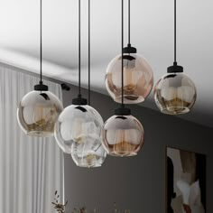 five clear glass globes hanging from a ceiling