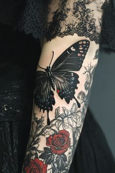 a woman's arm with a butterfly and roses tattoo on it