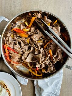 a pan filled with meat and vegetables on top of a table