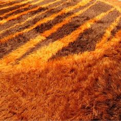 an orange and brown area rug with stripes on it