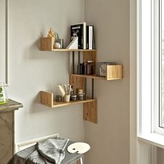 three wooden shelves in the corner of a room