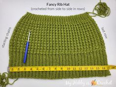 a crocheted green hat with a measuring tape