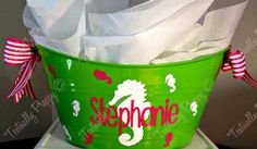 there is a green bucket with white tissue paper in it that says seahorse on the side