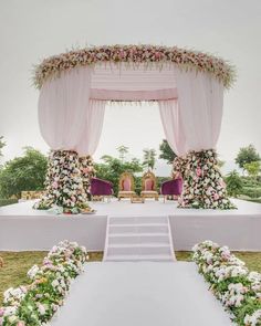 an outdoor wedding setup with pink and white flowers