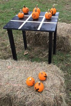 several pumpkins sitting on top of a table with faces drawn on them in the grass