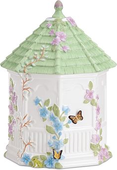 a green and white birdhouse with butterflies on it's roof is shown in front of a white background