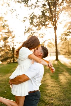 a man and woman are hugging in the grass