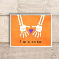 i love you to the bone card with two hands holding a heart on an orange background