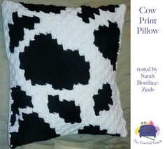 a black and white crocheted pillow with the words cow print pillow on it