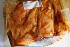 three pieces of fish wrapped in plastic on a plate